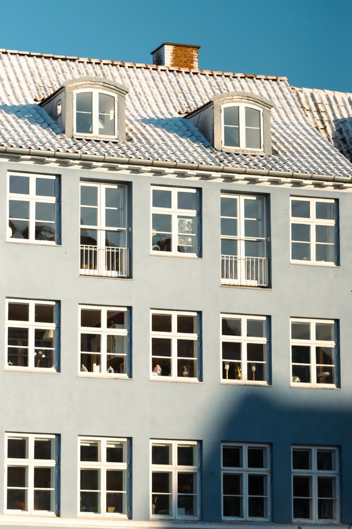 The Art of Drawing Readers In: Your attractive post title goes here Classic Scandinavian building in Copenhagen with snowy roof and pastel facade.